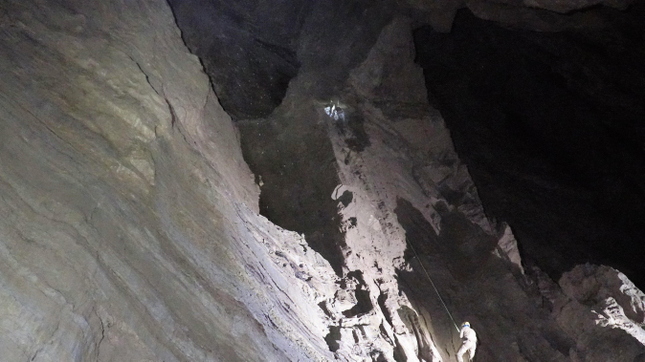 An explorer descends from one of the cave chambers.